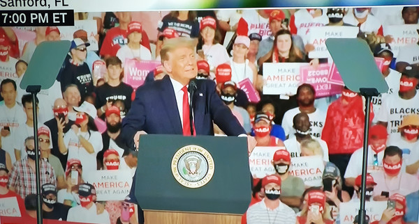코로나 확진후 10여일만에 음성판정을 받은 트럼프 대통령이 12일(현지시간) 플로리다 샌포드 공항에서 재개 첫 유세를 하고 있다.  청중들 상당수가  마스크를 쓰지 않았다.(CNN캡쳐)   